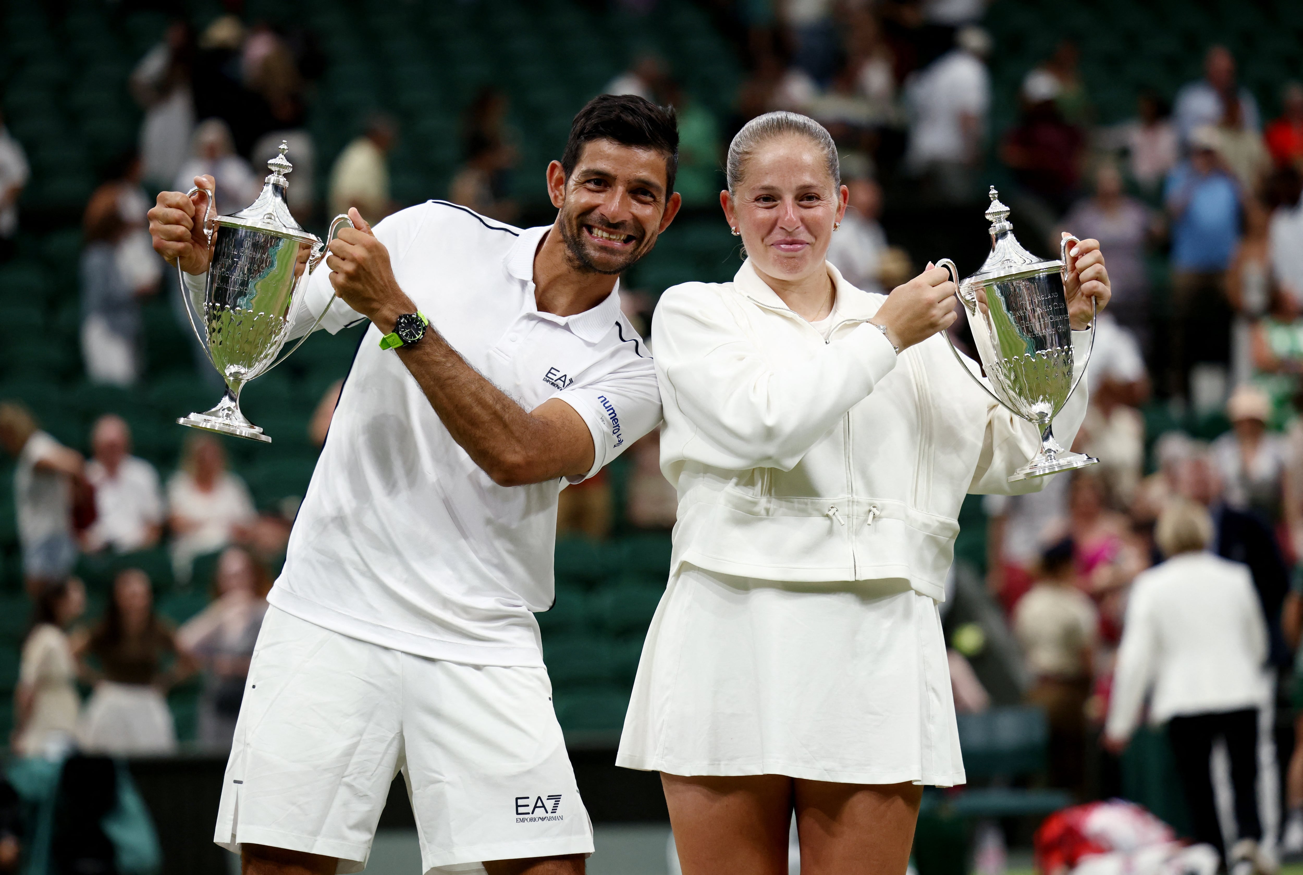 Tennis - Wimbledon - All England Lawn Tennis and Croquet Club, London, Britain - July 9, 2026 El Salvador's Marcelo Arevalo and Latvia's Jelena Ostapenko pose with the trophies after winning their mixed doubles final match against Australia's Marc Polmans and Australia's Storm Hunter REUTERS/Marko Djurica