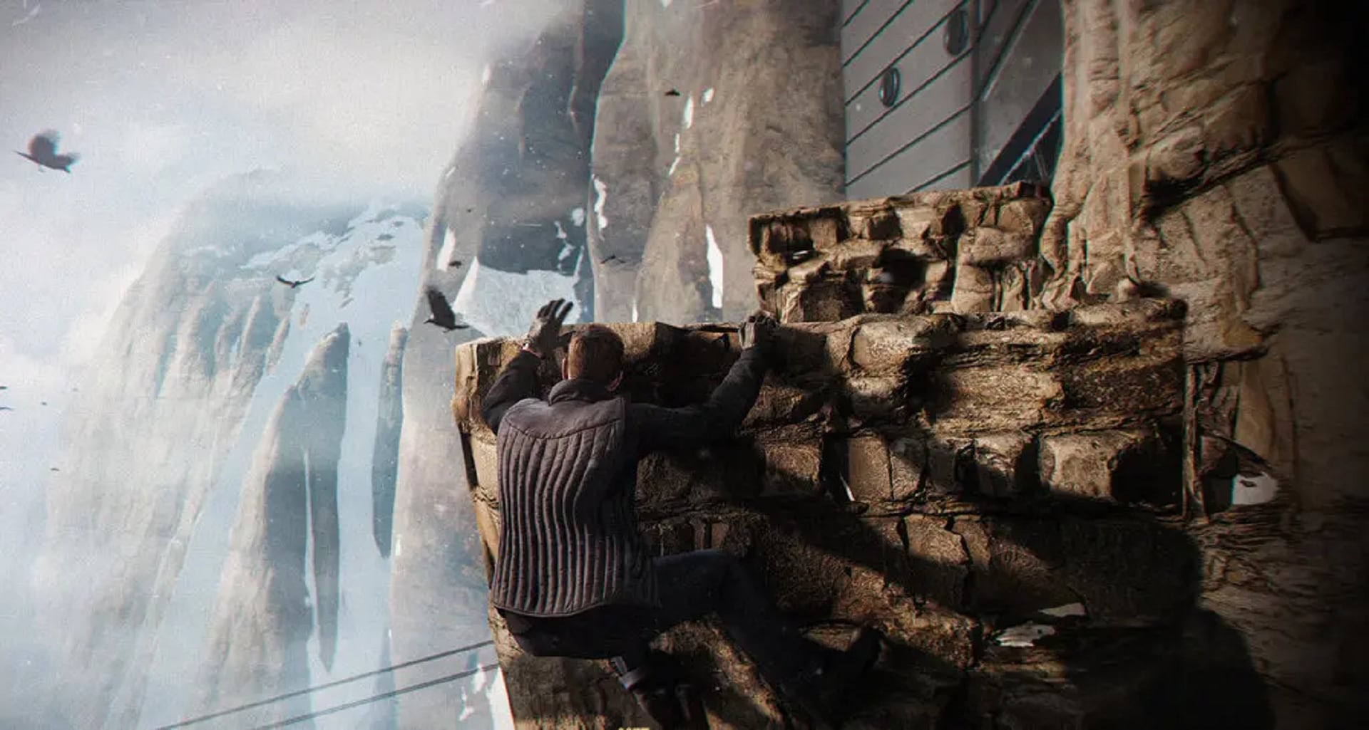 En una captura de pantalla del videojuego, un hombre vestido de oscuro se aferra al borde de un acantilado. 007 First Light fue creado por IO Interactive, el desarrollador detrás de la franquicia Hitman (Crédito: The New York Times / IO Interactive)