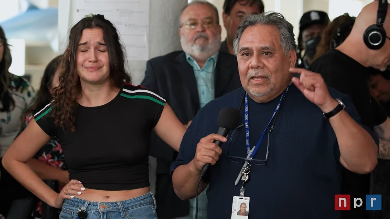 Felix Contreras sostiene un micrófono y habla en un evento de National Public Radio junto a Anamaria Artemisa Sayre y otros asistentes. (YouTube)