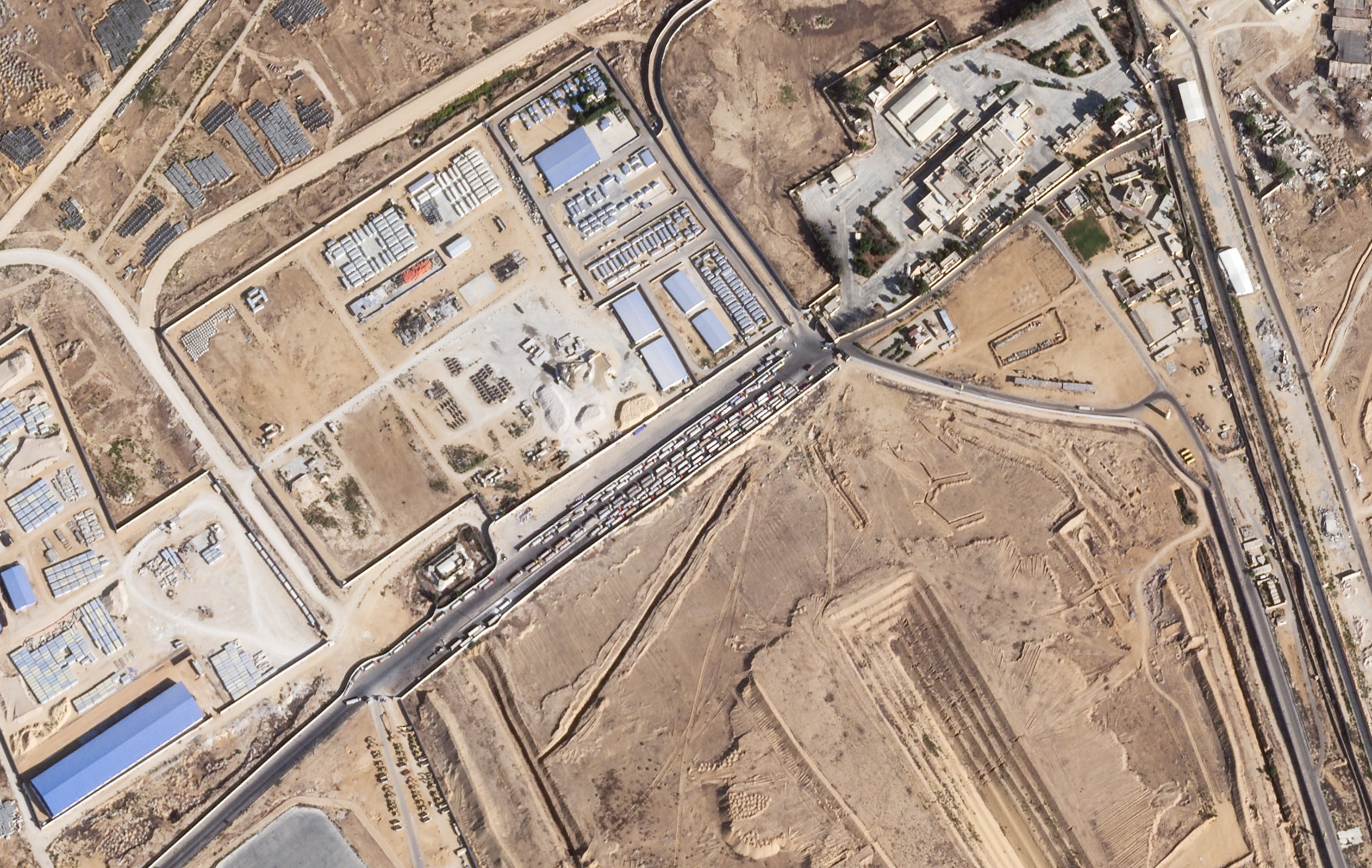 En esta imagen de satélite proporcionada por Planet Labs PBC se muestran camiones de ayuda alineados en el lado egipcio del cruce fronterizo de Rafah en la Franja de Gaza el jueves 16 de octubre de 2025 (Planet Labs PBC vía AP)