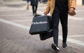 A shopper carries Debenhams Plc