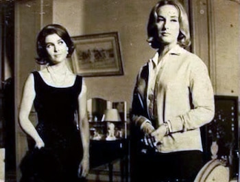 Fotografía en tonos sepia de Mónica Cahen d'Anvers con un vestido oscuro y Mirtha Legrand con una camisa clara, de pie en una sala