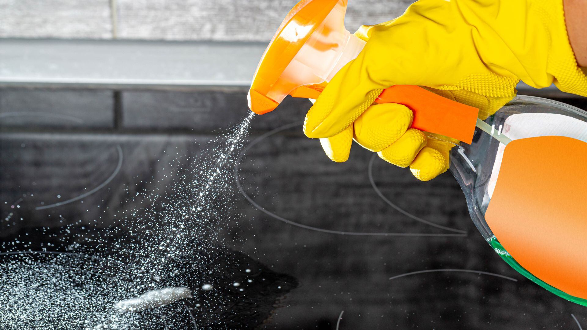 Una persona limpiando la vitrocerámica. (Canva)