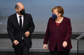 Social Democratic Party (SPD) candidate for chancellor Olaf Scholz speaks with acting Chancellor Angela Merkel as they attend a session of the German lower house of Parliament, Bundestag in Berlin, Germany, November 11, 2021. REUTERS/Annegret Hilse