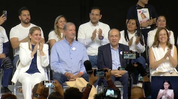 Varias personas sentadas en un escenario, incluyendo a Vicente Fox y Felipe Calderón, aplaudiendo. En primer plano, asistentes graban con teléfonos móviles y se ve una ventana de intérprete de lenguaje de señas.