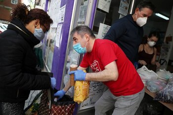 Una mujer recibe alimentos donados por voluntarios de la Asociación Vecinal de Aluche, en Madrid, España, el 16 de mayo de 2020. REUTERS/Susana Vera