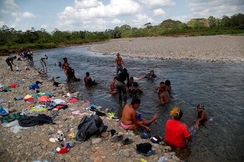 Migrantes haitianos se bañan en