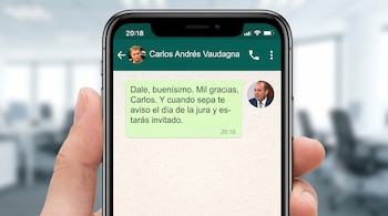 Una mano sostiene un teléfono móvil con pantalla donde se ve un chat de WhatsApp con el perfil de Carlos Andrés Vaudagna y un mensaje de texto.
