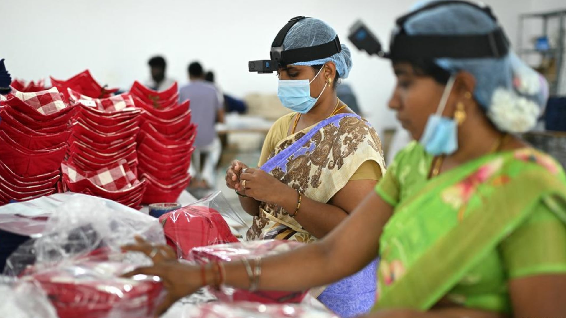 Mujeres tienen dispositivos en sus cabezas que graban sus actividades.
Imagen: R. Satish Babu/AFP