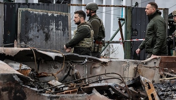 Ukainian President Volodymyr Zelensky (C) walks in the town of Bucha, northwest of the Ukrainian capital Kyiv, on April 4, 2022. - Ukraine's President Volodymyr Zelensky said on April 3, 2022 the Russian leadership was responsible for civilian killings in Bucha, outside Kyiv, where bodies were found lying in the street after the town was retaken by the Ukrainian army. (Photo by RONALDO SCHEMIDT / AFP)