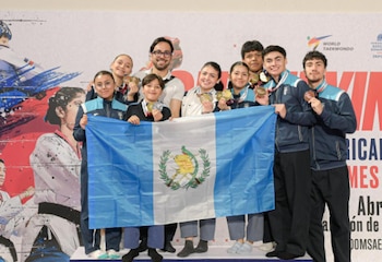La delegación guatemalteca de Poomsae posa con la bandera y sus medallas tras una histórica jornada en el Open de República Dominicana 2026 (Foto cortesía Taekwondo Guatemala).