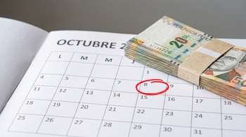 Un fajo de billetes de soles peruanos sobre un calendario del mes de octubre que tiene el número 8 encerrado en un círculo rojo.