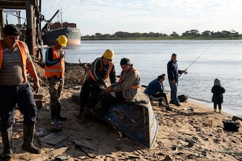 Trabajadores del puerto de Caacupemi toman un descanso en el río Paraguay en Asunción, Paraguay (AP/Rodrigo Abd/Archivo)