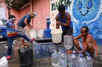 Personas extraen agua de una fuente desconocida en el barrio de bajos ingresos de Petare, en Caracas, Venezuela, el 12 de mayo de 2023. REUTERS/Gaby Oraa
