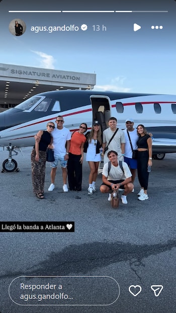 Ocho personas, entre hombres y mujeres, posan frente a un avión privado blanco y negro con la puerta abierta, en una pista de aeropuerto
