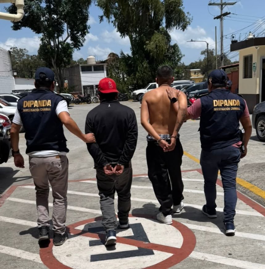 Agentes de la unidad de investigación criminal DIPANDA custodian a dos hombres esposados en un área exterior. (PNCdeGuatemala)