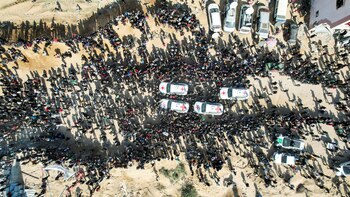 Una vista de dron muestra a personas reunidas cerca de vehículos del Comité Internacional de la Cruz Roja (CICR).