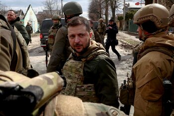 El presidente Volodimir Zelenskiy observa detenidamente rodeado de militares ucranianos mientras continúa la invasión rusa de Ucrania, en Bucha (Reuters)