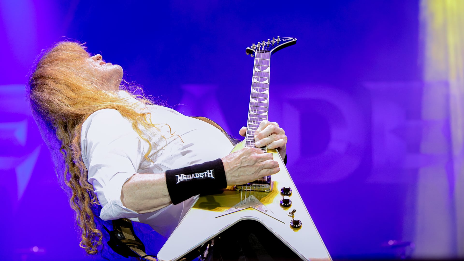 Dave Mustaine de Megadeth, con su característica cabellera rojiza, interpreta la guitarra en el escenario durante su enérgica presentación en Argentina
