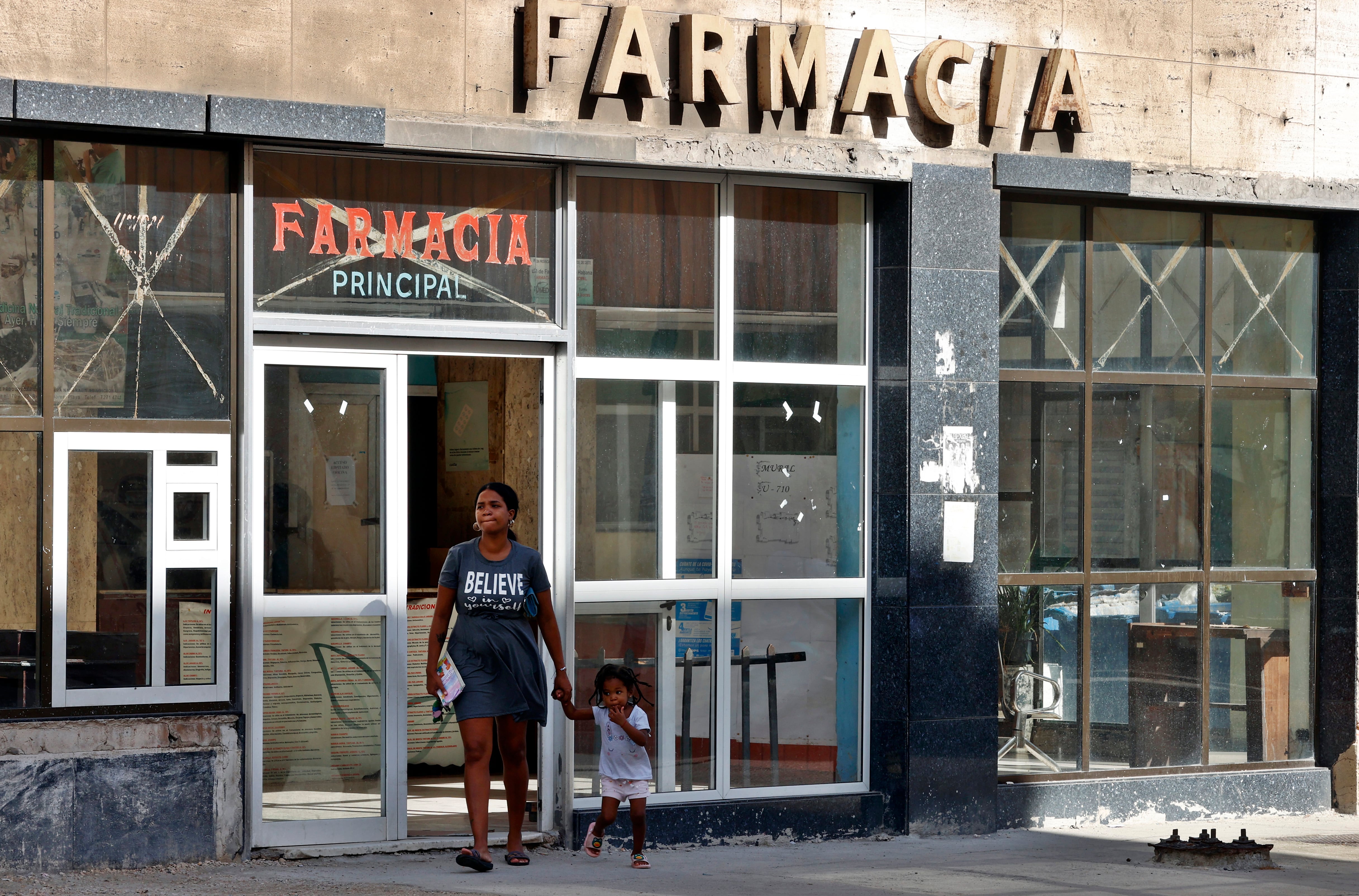 Una mujer con un niño sale de una farmacia en La Habana (EFE/Ernesto Mastrascusa/Archivo)