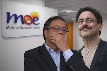 Gustavo Petro, con gafas y la mano en la boca, e Iván Cepeda, con gafas y bigote sonriendo, observan atentos. Al fondo, el logo de la MOE.