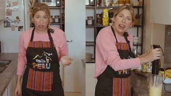 Flor Bertotti en una cocina moderna, vistiendo un delantal negro con detalles peruanos, gesticulando y usando una batidora de mano para preparar una salsa amarilla
