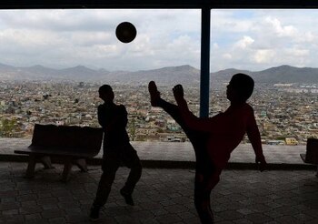 Afghan children play football at