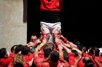People form the foundation of a human tower during the first performance of Colla Joves Xiquets de Valls and Colla Vella Dels Xiquets de Valls after the coronavirus disease (COVID-19) pandemic halt, at Blat square in Valls, Spain, June 24, 2021. REUTERS/ Albert Gea
