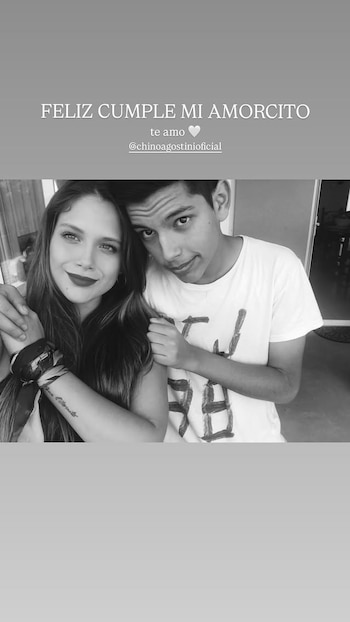 Fotografía en blanco y negro de una mujer y un hombre sonriendo y abrazándose. Sobre ellos, un texto dice "FELIZ CUMPLE MI AMORCITO te amo @chinoagostinioficial"