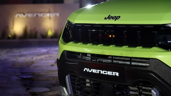 Primer plano de la parte delantera de un automóvil verde con el emblema de Jeep y la inscripción Avenger en el paragolpes