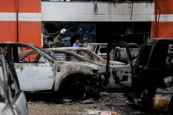 Un hombre camina afuera de la oficina del fiscal departamental de Santa Cruz que fue incendiada durante la noche, en Santa Cruz, Bolivia, el jueves 29 de diciembre de 2022. (AP foto/Ipa Ibanez)
