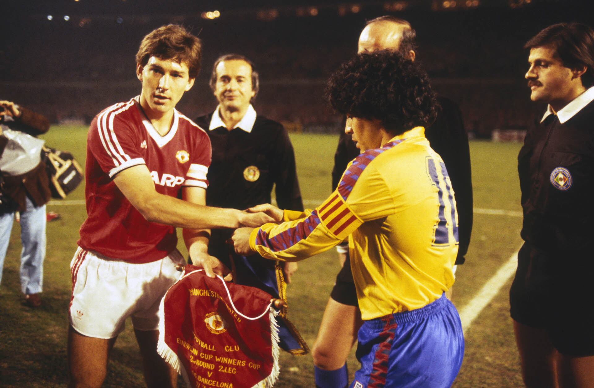 El capitán Bryan Robson (izquierda) del Manchester United le da la mano al capitán del Barcelona Diego Maradona antes del partido de vuelta de cuartos de final de la Recopa de Europa entre el Manchester United y el Barcelona celebrado el 21 de marzo de 1984 en Old Trafford, en Manchester, Inglaterra. El Manchester United ganó el partido por 3-0, ganando la eliminatoria por un global de 3-2. (Foto de Trevor Jones/Getty Images)