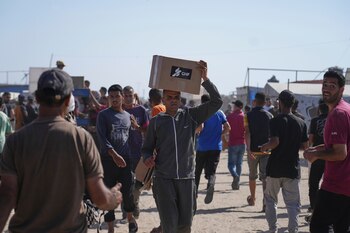 Palestinos llevan cajas que contienen