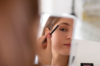 Una mujer se perfila las cejas (Magnific)
