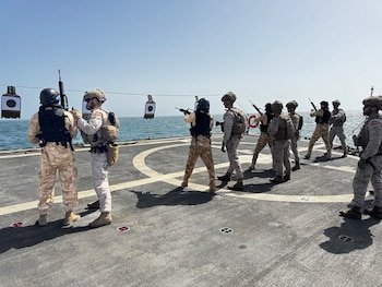 Un grupo de militares con uniforme de camuflaje, chalecos, cascos y fusiles, se alinea sobre la cubierta de un buque con blancos de tiro sobre el mar en Mauritania