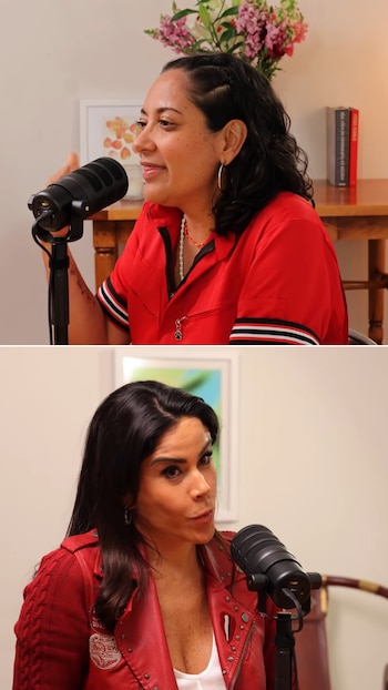 Dos mujeres hablan en micrófonos de estudio. La primera lleva camisa roja con rayas en las mangas; la segunda, chaqueta de cuero roja. Hay plantas y libros al fondo