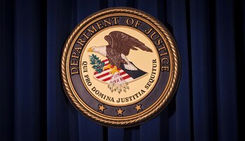 FILE PHOTO: The Department of Justice (DOJ) logo is pictured on a wall after a news conference in New York December 5, 2013.//File Photo