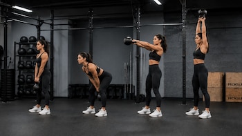 Secuencia de cuatro imágenes de una mujer con ropa deportiva negra realizando un swing con kettlebell en un gimnasio con pesas de fondo