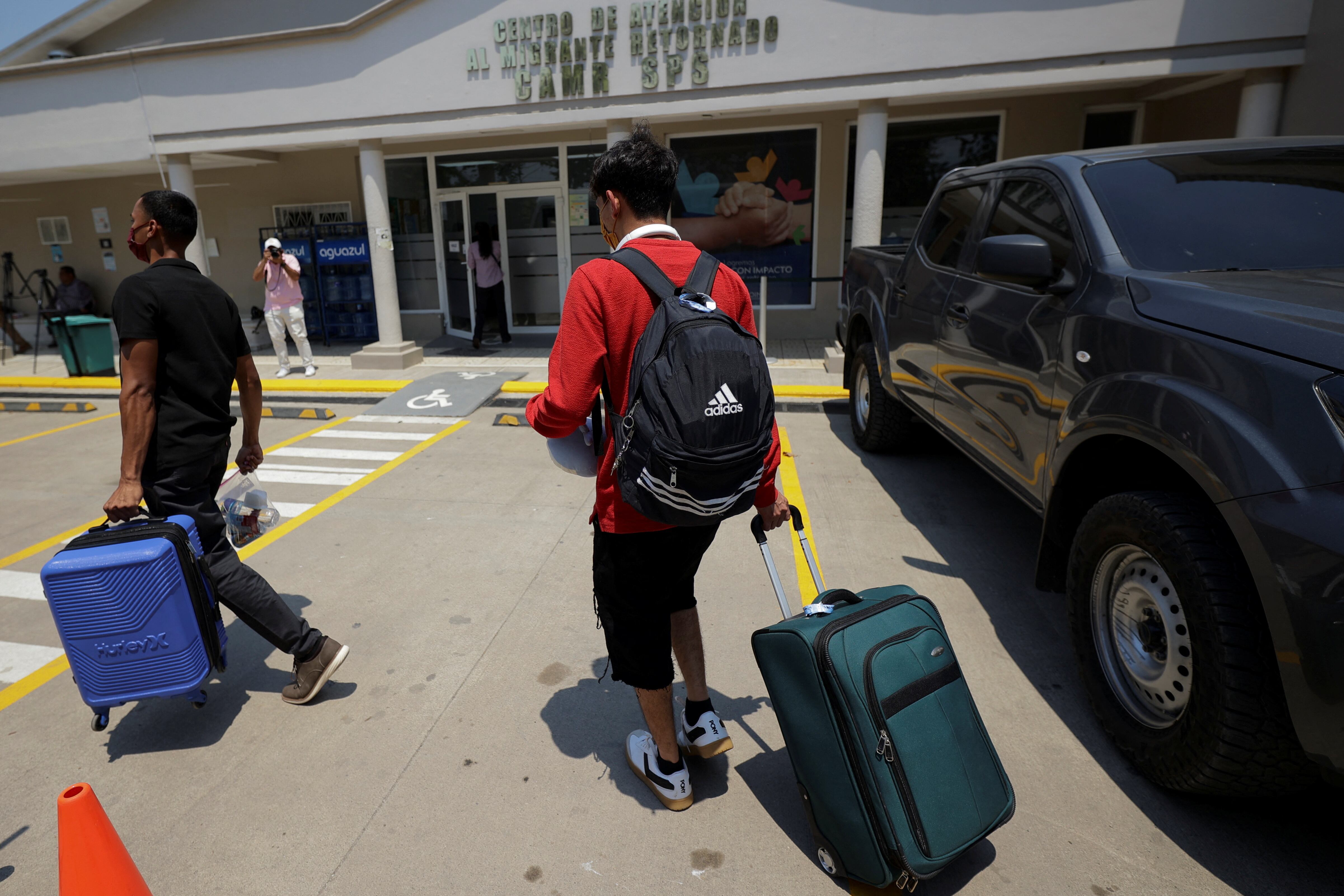 Migrantes hondureños que regresaron voluntariamente de Estados Unidos utilizando la aplicación CBP Home, parte de una iniciativa de la administración del presidente estadounidense Donald Trump que fomenta la autodeportación de inmigrantes indocumentados, caminan en el Centro de Atención a Migrantes Retornados, en San Pedro Sula, Honduras. REUTERS/Yoseph Amaya