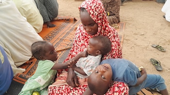 Una refugiada sudanesa con sus hijos cerca de la frontera entre Sudán y Chad, en Koufroun, Chad, 29 de abril de 2023. REUTERS/Mahamat Ramadane/Archivo