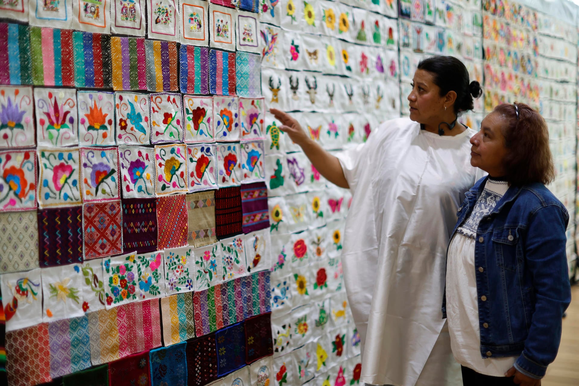 Dos mujeres observan la exposición de bordados y tejidos más grande del mundo este lunes, en el Complejo Cultural Los Pinos de la Ciudad de México (México)