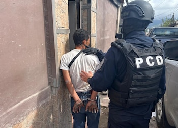 Oficiales de la PCD trasladan a uno de los sospechosos detenidos, identificado como integrante de la estructura criminal “Los Maruja”. Crédito: Ministerio de Seguridad Pública