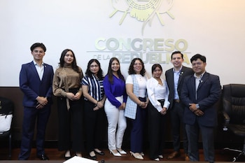 Ocho personas, seis mujeres y dos hombres, de pie frente a una pared blanca con el logo del Congreso de la República y su nombre