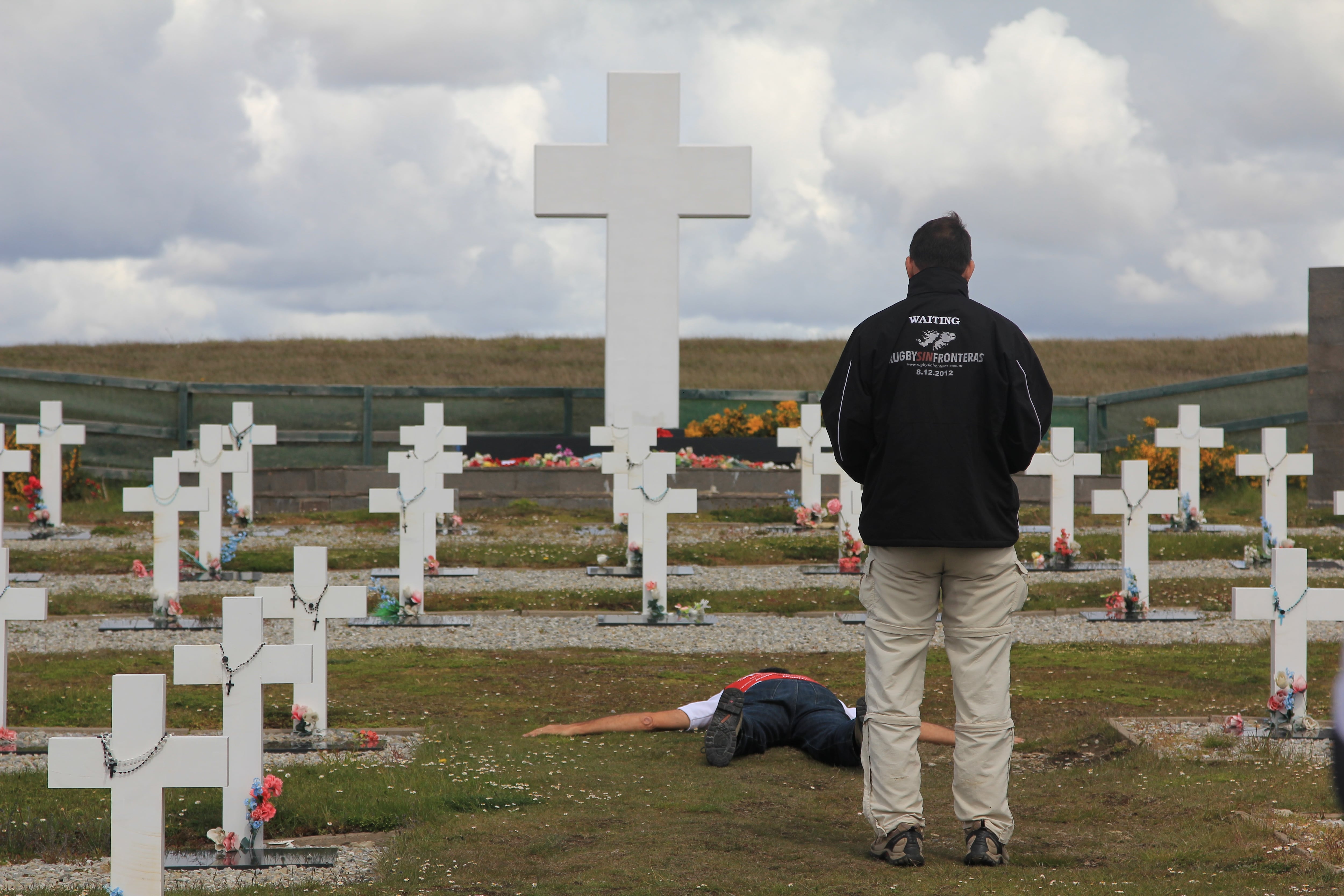 Alejandro en el cementerio de Darwin, de espaldas y con el rostro hundido en la turba
