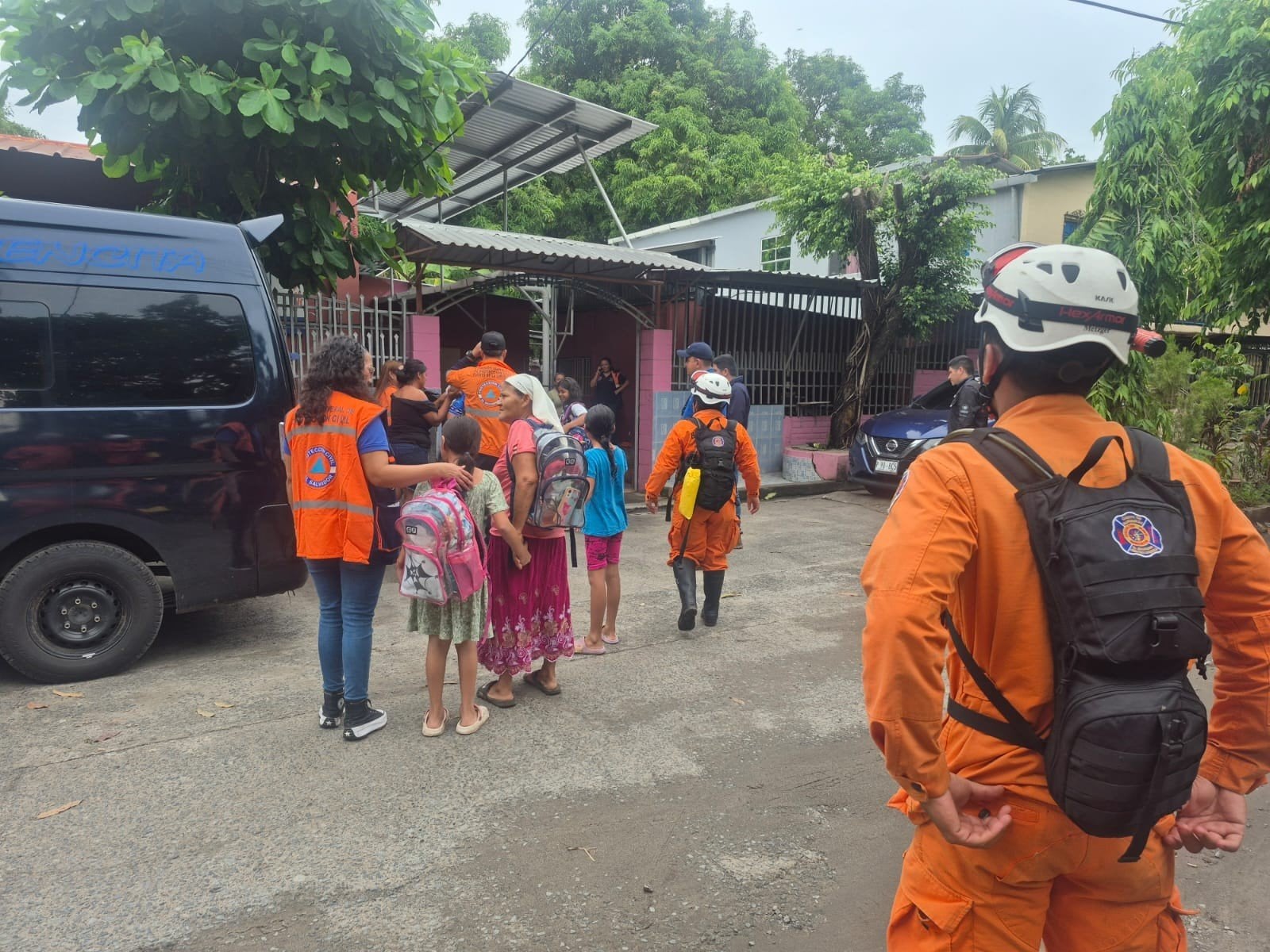 Equipos de Protección Civil colaboran en la evacuación de familias, incluidos varios menores, hacia albergues seguros ante las emergencias provocadas por la depresión tropical Cristina en El Salvador (Cortesía Cuerpo de Bomberos).