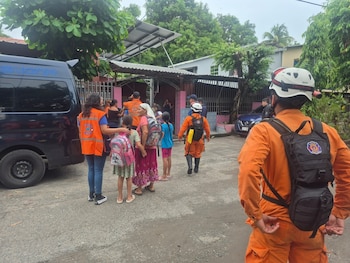 Equipos de Protección Civil colaboran en la evacuación de familias, incluidos varios menores, hacia albergues seguros ante las emergencias provocadas por la depresión tropical Cristina en El Salvador (Cortesía Cuerpo de Bomberos).