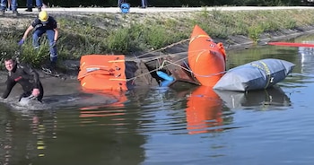 Un buzo en el agua, socorristas en la orilla y varios globos inflables amarrados a una estructura sumergida