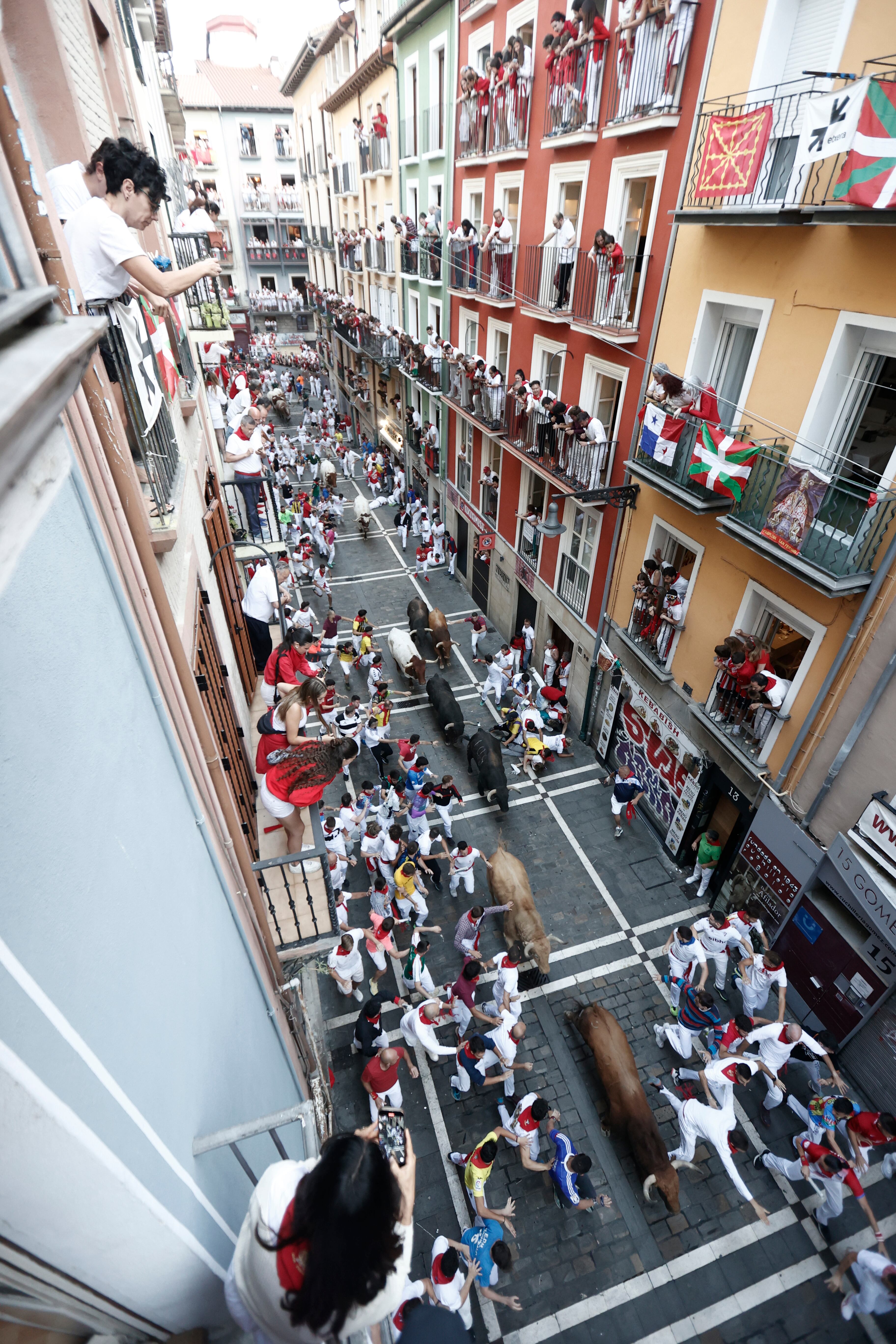 Los mozos corren al paso de los toros de la ganadería Jandilla durante el quinto encierro. (EFE/Jesús Diges)