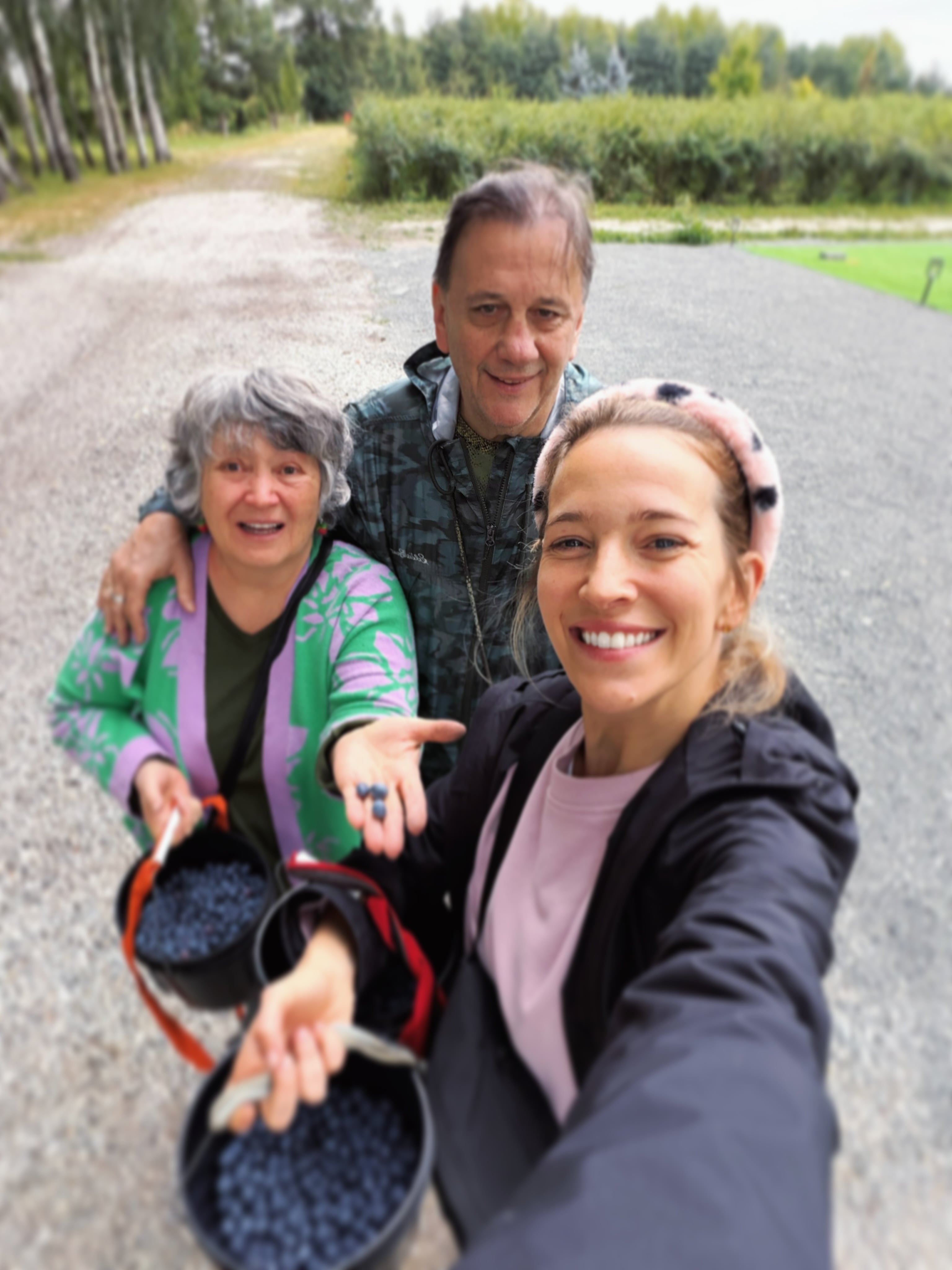 Luisana y sus padres, Beatriz y Eduardo, posaron con baldes llenos de arándanos