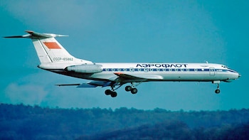 Avión blanco con franjas azules y logo Aeroflot, matrícula CCCP-65862 en la cola roja. Tren de aterrizaje extendido. Fondo de cielo azul y vegetación